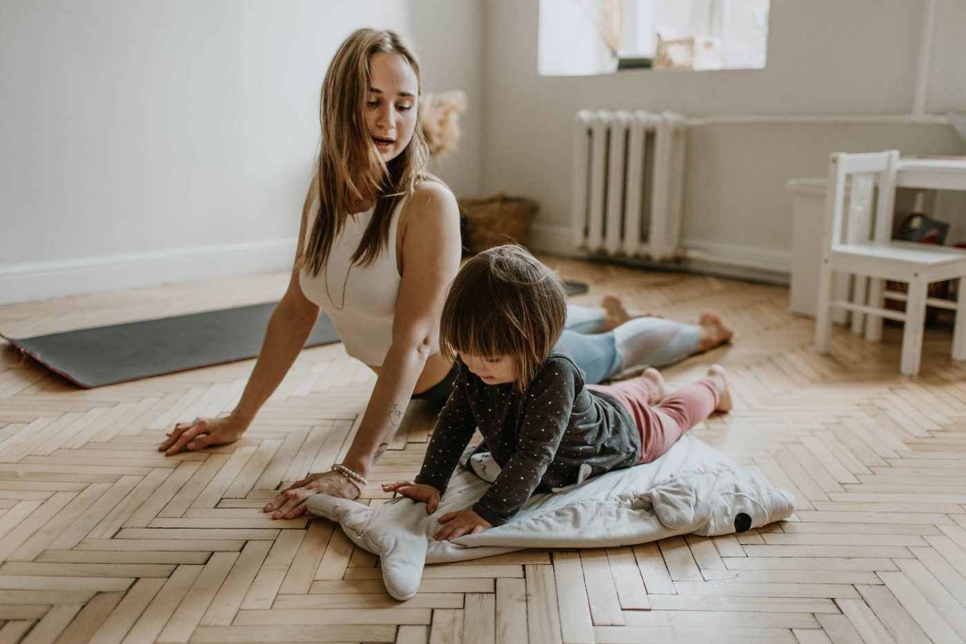 A group of people folded forward in Child's Pose on mats outdoors
